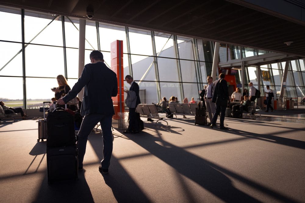Traveller with luggage walking through an airport terminal